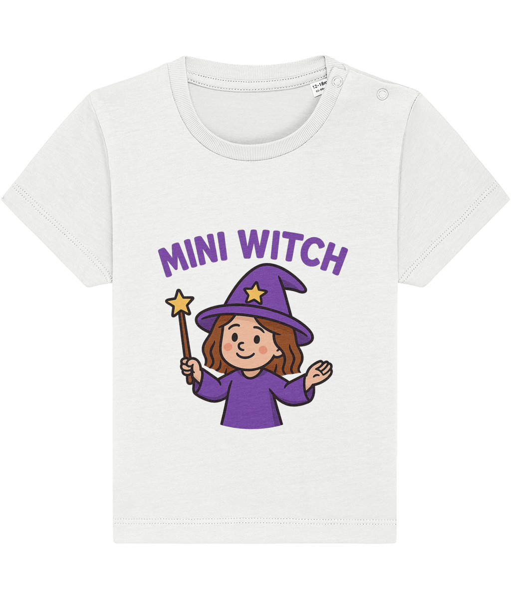 White toddler T-shirt displaying a smiling cartoon mini witch in purple hat and robe holding a star-tipped wand; centered graphic with arched purple text MINI WITCH above on plain background.