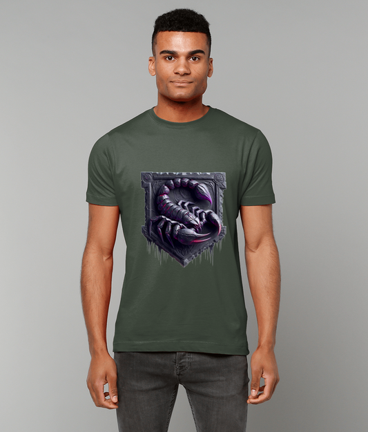 Scorpion graphic curls with a raised tail and open pincers on the chest of an olive green t-shirt worn by a person standing against a plain light gray background.