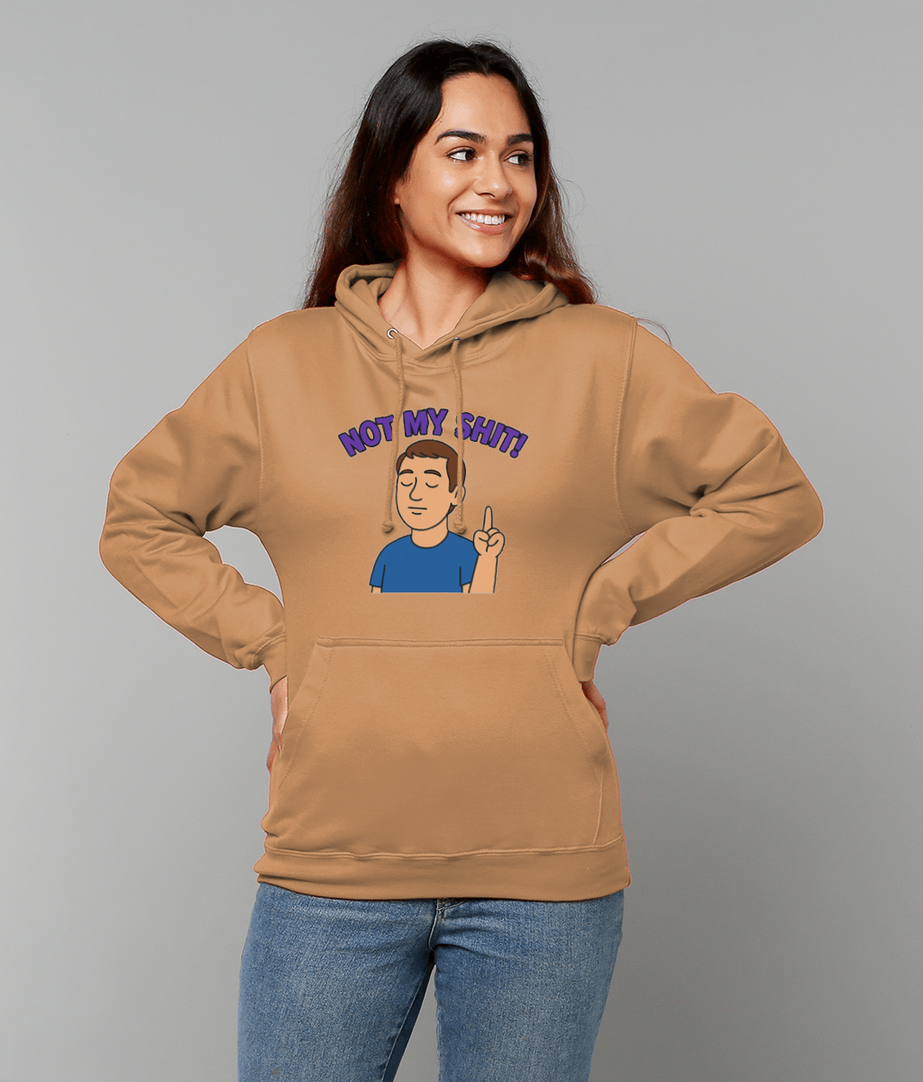 Woman wearing a tan hoodie printed with a cartoon man raising one finger and the text 'NOT MY SHIT!' standing with hands on hips against a plain light gray background.