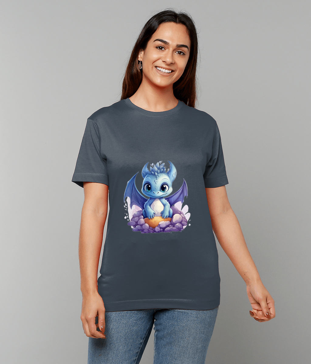 Blue baby dragon sits on purple rocks printed on a dark gray T-shirt worn by a smiling woman against a neutral gray studio background.