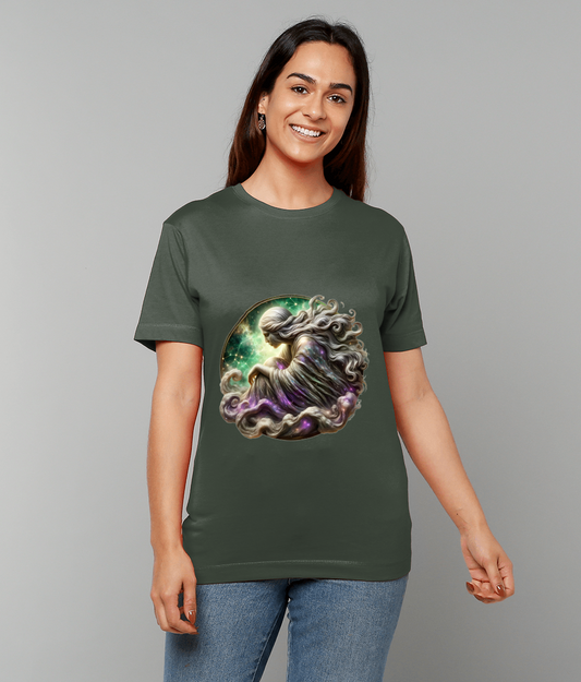Cosmic robed figure curled in a fetal pose printed on a dark green T-shirt, swirling hair and nebula colors glowing, worn by a smiling person against a plain gray background.