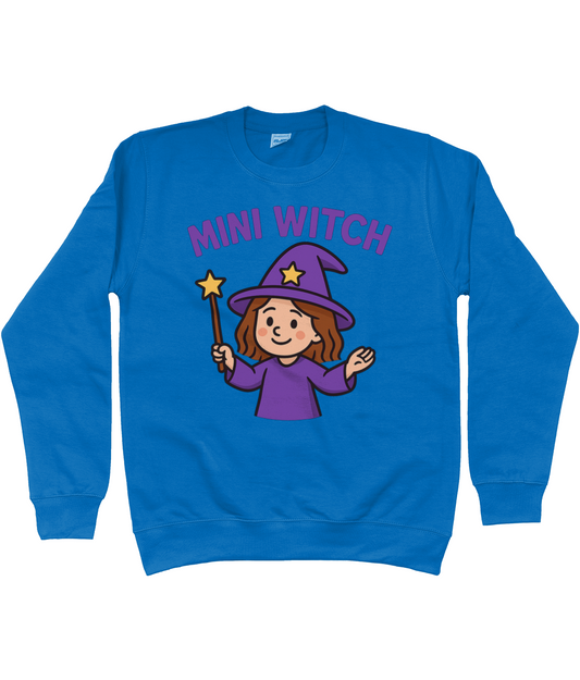Blue sweatshirt displaying a cartoon girl witch wearing a purple hat and robe, smiling and holding a star topped wand while waving, centered on white background. Text reads "MINI WITCH".