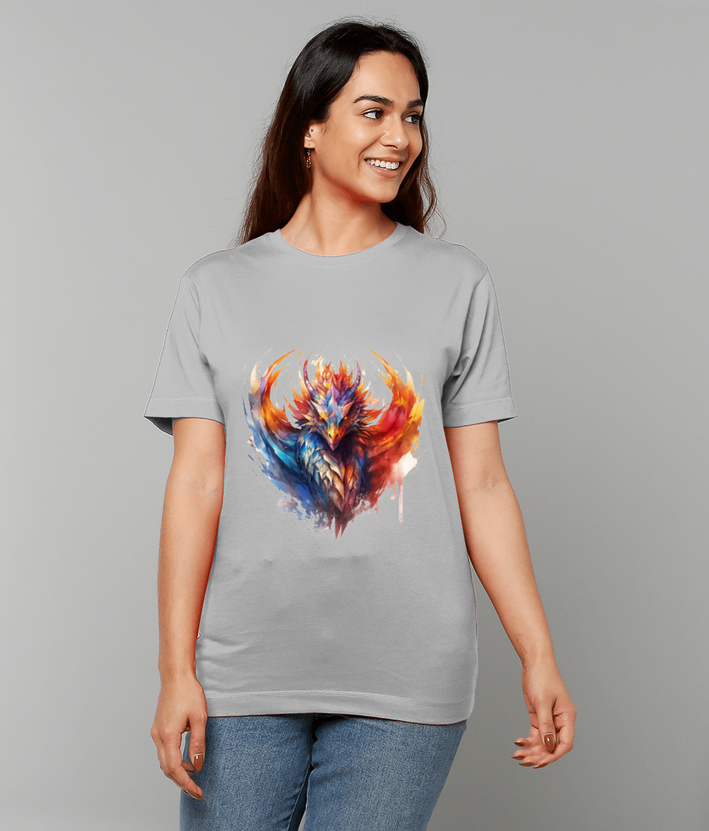 A colorful phoenix illustration erupts with red orange and blue feathers, printed on a light-gray T-shirt worn by a smiling woman standing against a plain gray background.