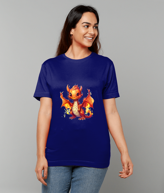 Royal blue T-shirt printed with an orange baby dragon is worn by a smiling woman standing with hands at her sides against a plain light gray background and wearing jeans.