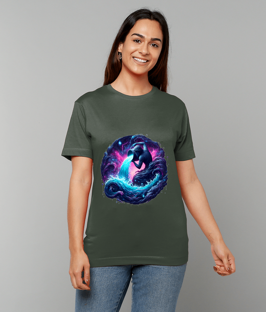 Green t-shirt displays a circular cosmic illustration of a whale-like creature pouring a glowing stream of water that forms swirling blue-purple waves while a smiling woman poses against a plain gray background.