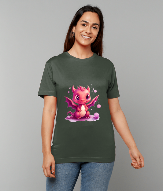 Pink cartoon baby dragon sits with wings spread on a dark green T-shirt worn by a smiling young woman standing against a plain light gray background.