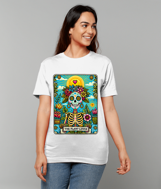 A colorful sugar skull skeleton graphic with flowers and plants sits centered on a white tee worn by a smiling person against a gray background, text reads THE PLANT LOVER