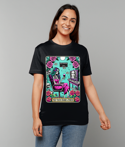 A woman wears a black T-shirt depicting a skeleton in a chair holding a glass of wine surrounded by roses and skulls in a teal frame, text: "THE TRUE CRIME JUNKIE".