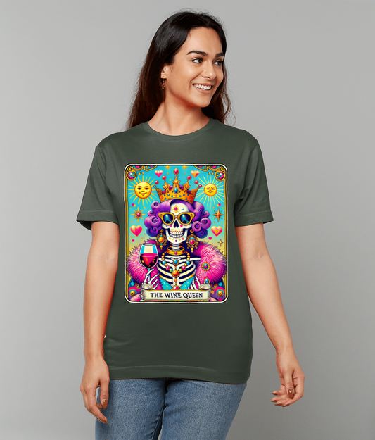 Tarot-style skeleton queen holds a wine glass on a green T-shirt labeled THE WINE QUEEN, surrounded by suns hearts and stars; a woman wears it against a plain gray background.