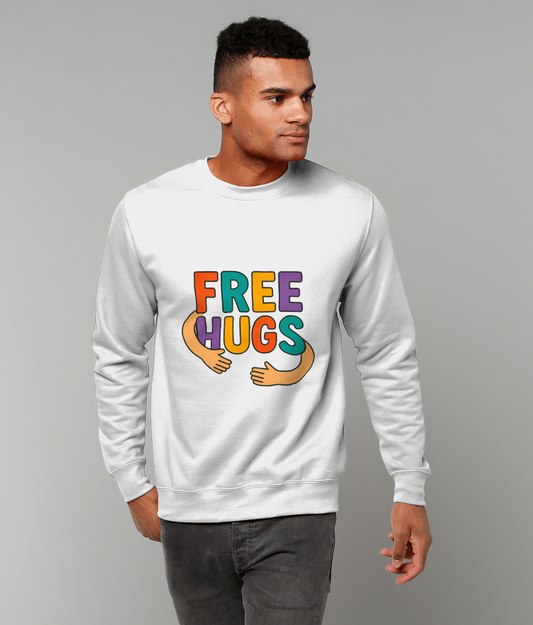 White sweatshirt reading "FREE HUGS" with colorful letters and cartoon arms appearing to hug; worn by a standing young man in jeans against a plain light gray studio background.