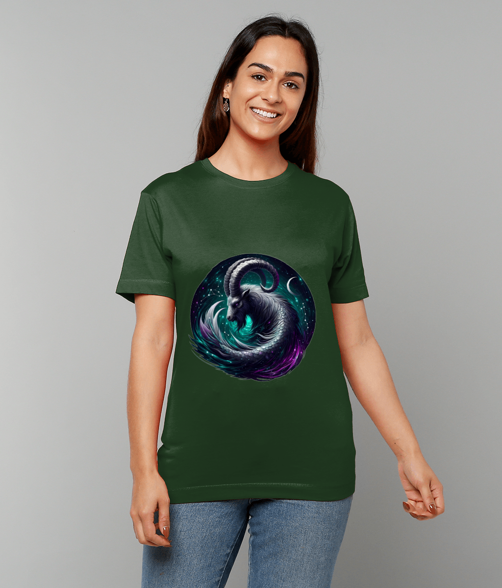 Green T-shirt shows a circular cosmic ram illustration; the person smiles and stands against a plain light gray background, hands relaxed at sides, wearing blue jeans.