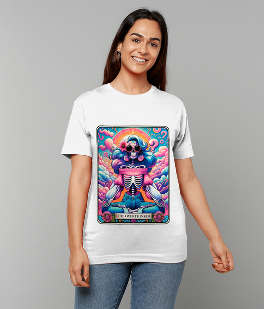 Smiling woman wearing a white T-shirt whose front shows a colorful psychedelic skeleton with flowing blue hair sitting cross-legged amid pink clouds; text on the design reads THE OVERTHINKER.
