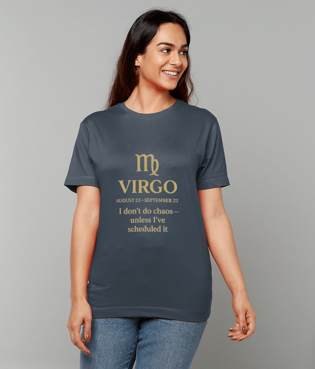 Woman smiling and looking right stands against a plain gray background wearing a navy T-shirt and jeans; the shirt shows a Virgo glyph and the text: VIRGO AUGUST 23–SEPTEMBER 22 I don't do chaos — unless I've scheduled it