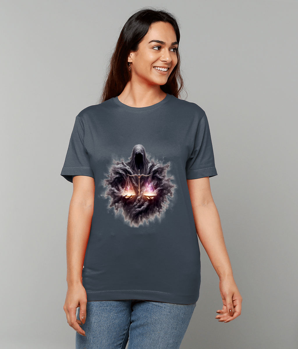 Ghostly hooded figure on a T-shirt holds glowing scales amid a smoky aura while a smiling woman stands against a plain gray background wearing jeans.