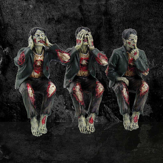 Three zombie figures are posed sitting, blocking their ears, eyes, and mouth in a "hear no evil, see no evil, speak no evil" manner, against a dark, textured backdrop.