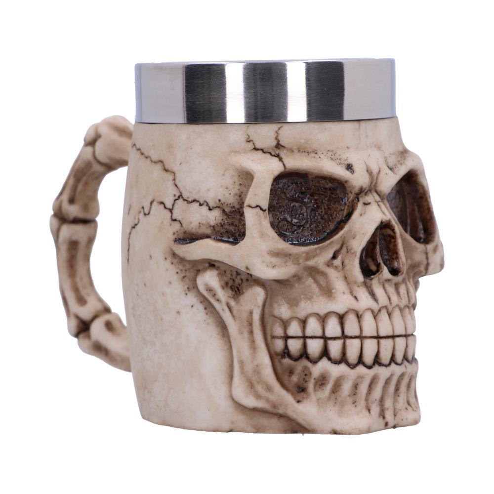 A mug styled like a skull with intricate detailing, featuring a metal rim, serves as a drinking vessel against a plain white background.