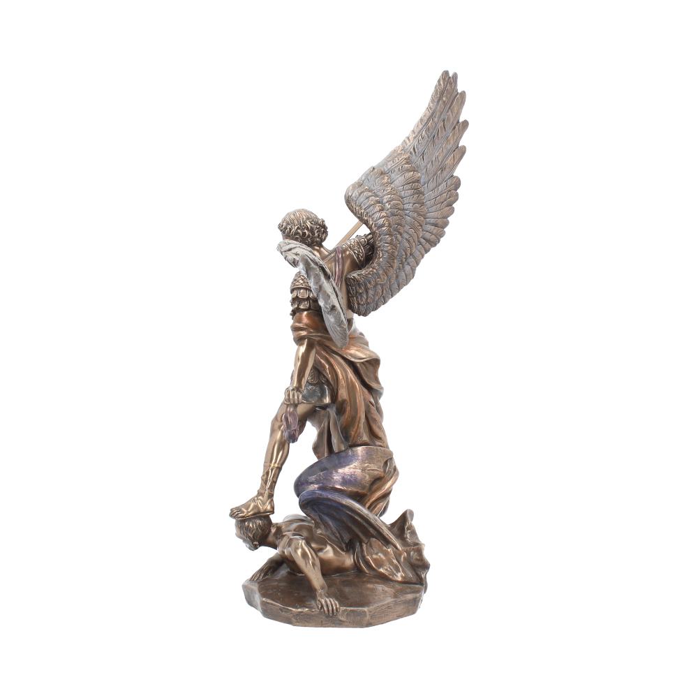 A bronze statue shows a winged angel stepping on another figure. The angel has a shield, and the other figure is on its knees. The background is plain.