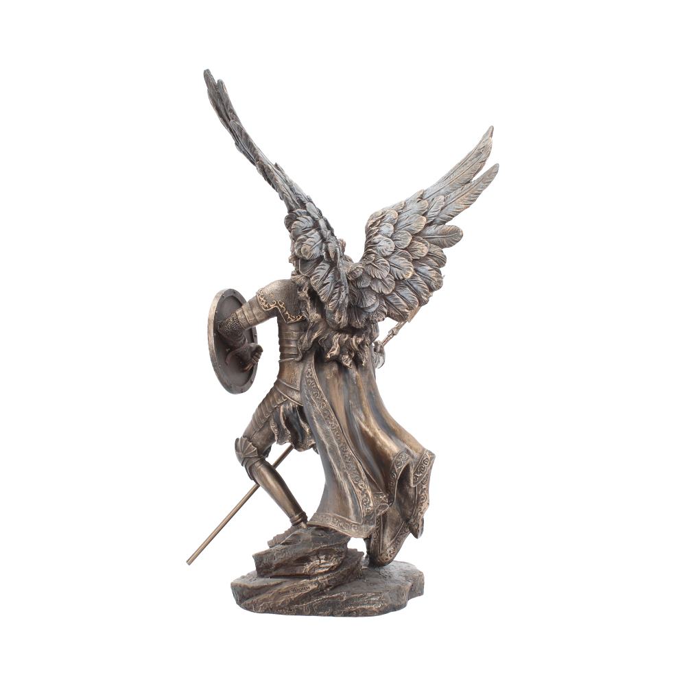 A bronze-colored angel statue stands, wings outstretched and ready for flight, holding a shield and sword in its hands; it is displayed on a white surface.
