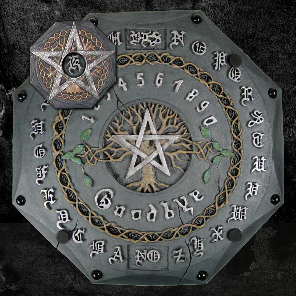 A hexagonal Ouija board with ornate lettering and a pentagram in the center is surrounded by numbers and letters. “Goodbye” is written at the bottom. The board lies on a textured surface.