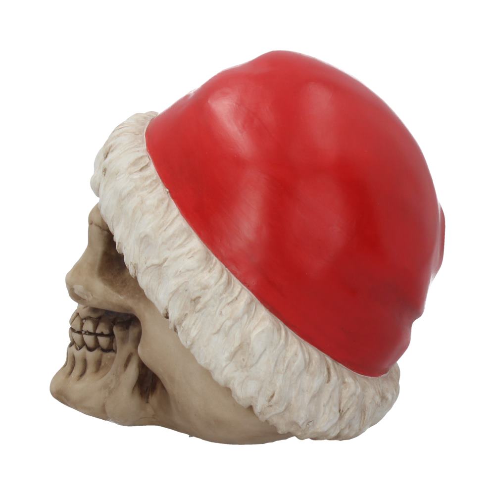 A skull wears a red Santa hat, positioned sideways, revealing grinning teeth within a plain white background.