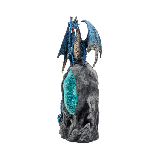 A blue, winged dragon figurine stands perched on a rocky pedestal with a textured, turquoise crystal cavity, suggesting a mystical or fantasy-themed environment.