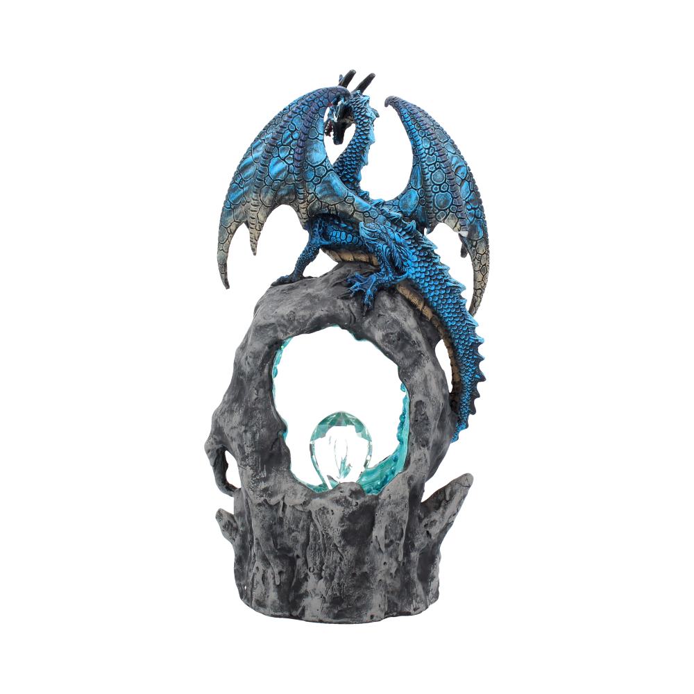 A blue dragon figurine perches atop a weathered, stone-like structure with an open circle, highlighting an illuminated crystal in its center.