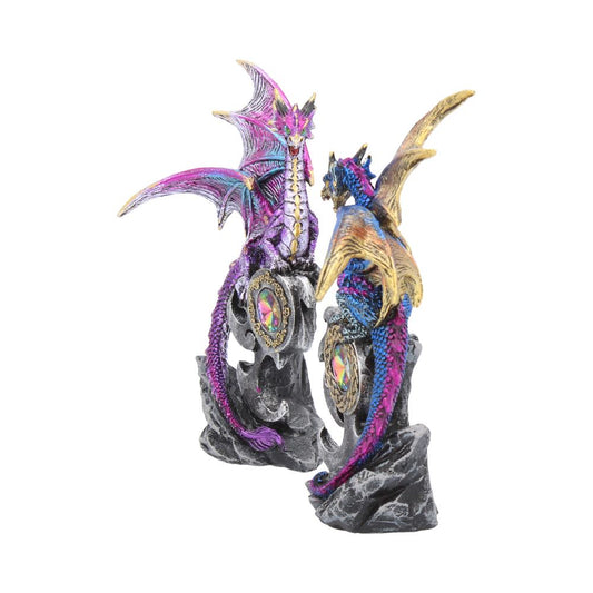 Two colorful dragon figurines perch on rocky bases, each holding a decorative orb. The dragons have vibrant scales in purple, blue, and gold, set against a plain white background.