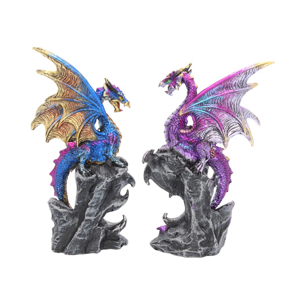 Two vibrantly colored dragon figurines, one blue and gold, the other purple and silver, perched on rocky bases, facing each other in a confrontational or conversational pose.