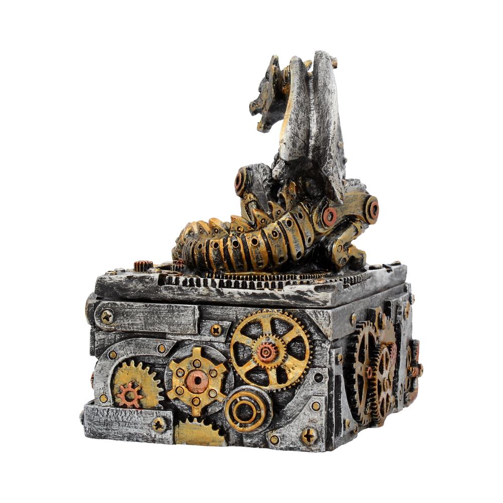 A steampunk-style dragon sculpture featuring industrial gears and mechanisms rests atop a square, metallic box. The dragon appears intricately detailed, blending mechanical elements with fantasy design.