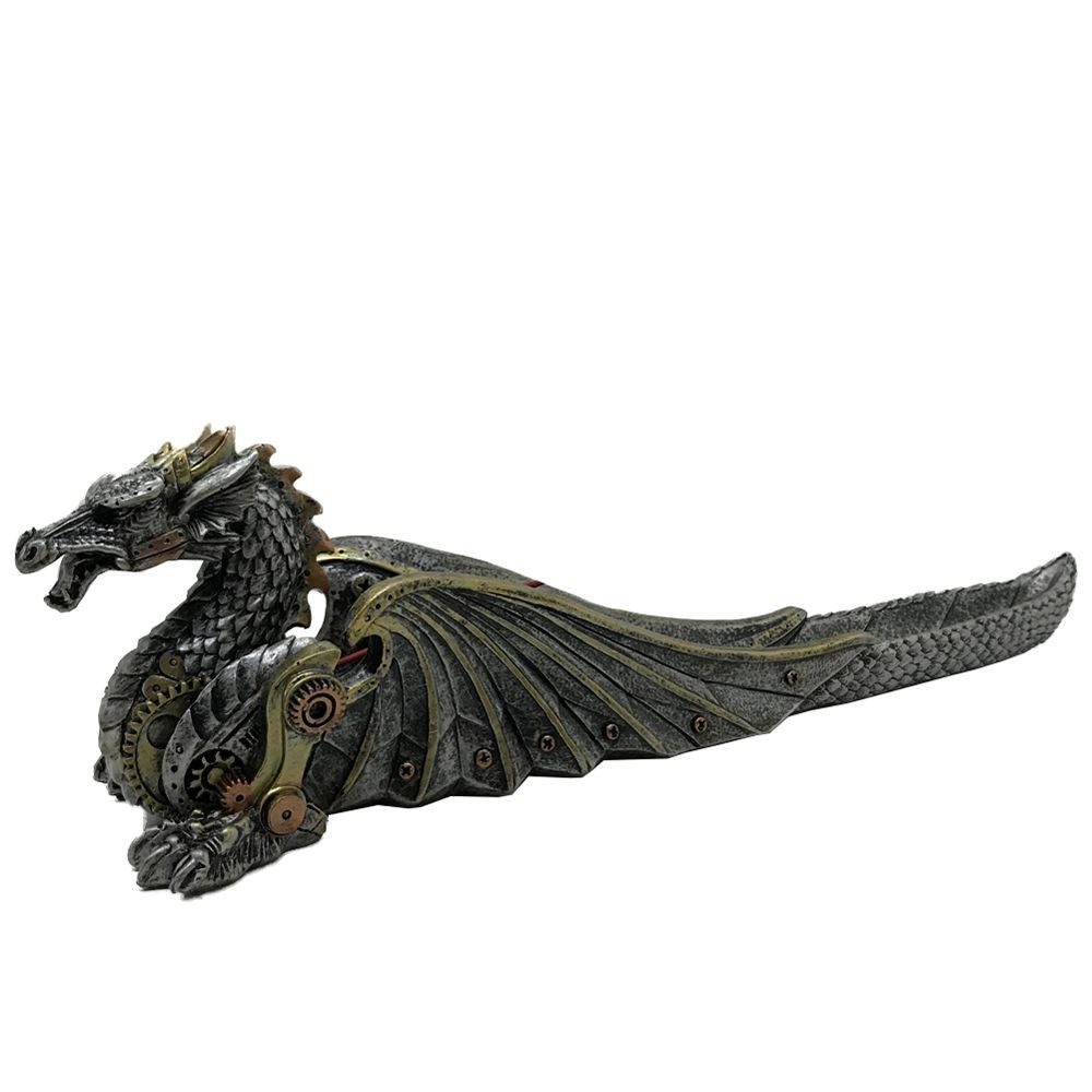 A steampunk dragon incense burner rests on a white background. The dragon is sculpted in grey and gold metal tones, its body forming a long, shallow trough.