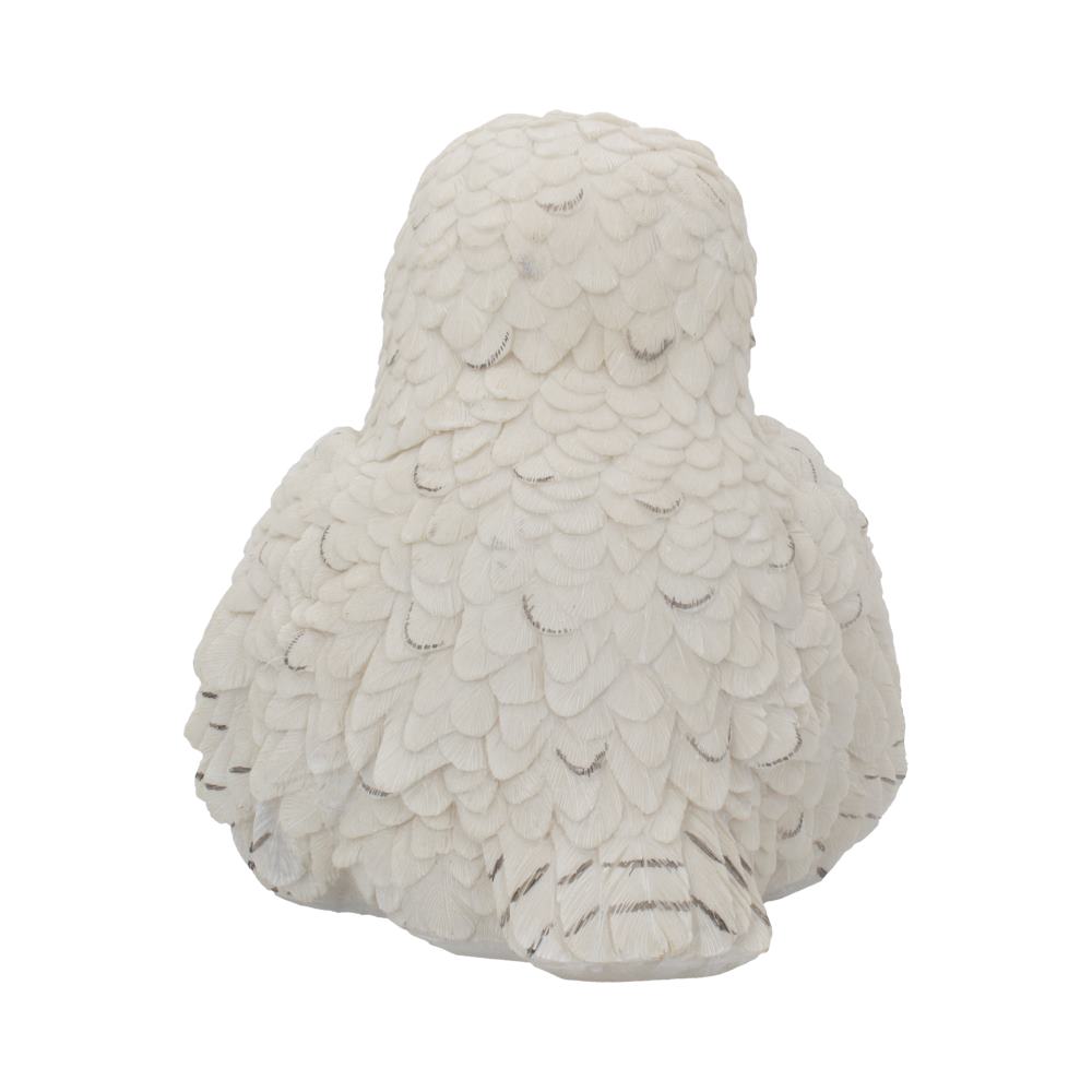 A white, intricately detailed owl sculpture sits against a plain background, displaying layered feathers in a sitting posture, conveying a sense of calm and elegance.