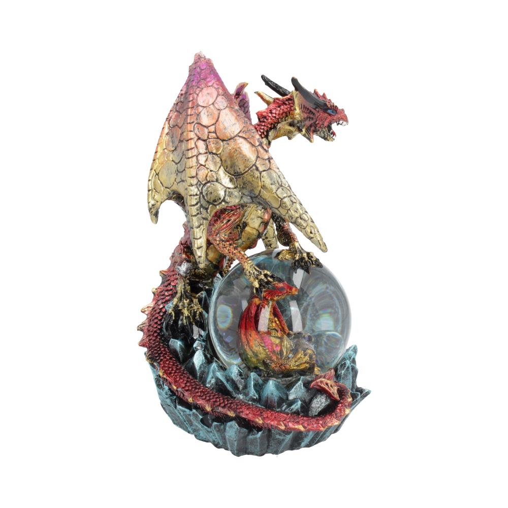 A dragon figurine rests atop a snow globe, its body partially encircling the sphere, which contains a smaller dragon.
