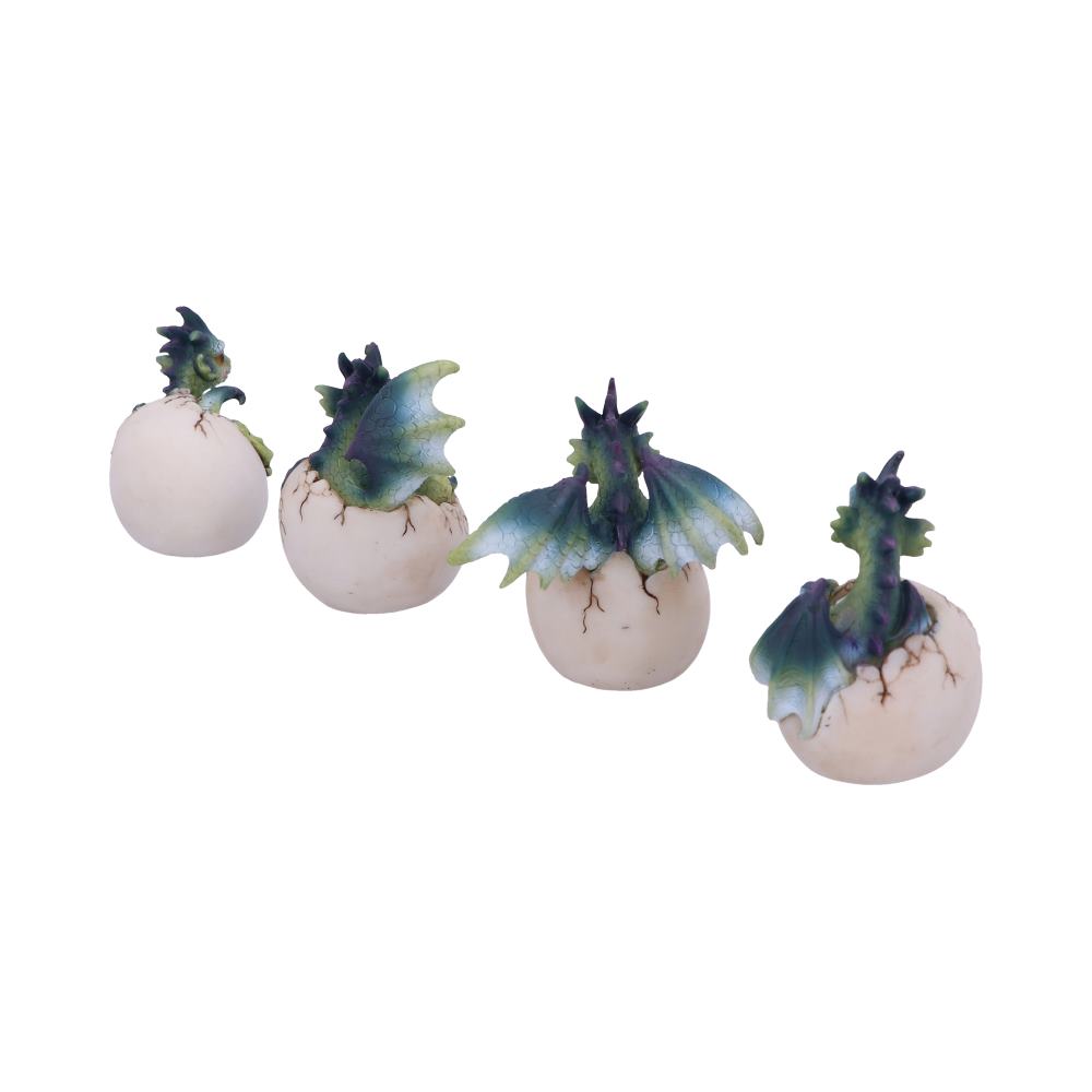 Four small dragon figurines emerge from cracked eggs, showcasing varying stages of hatching with green wings and spikes. They are set on a plain white background.