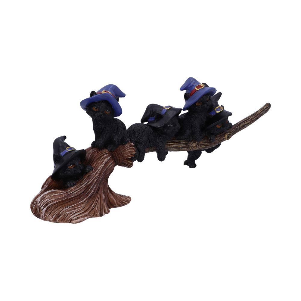 Five black kittens wearing blue witch hats sit playfully on a broomstick, with one kitten lounging at the base, creating a whimsical Halloween-themed scene.