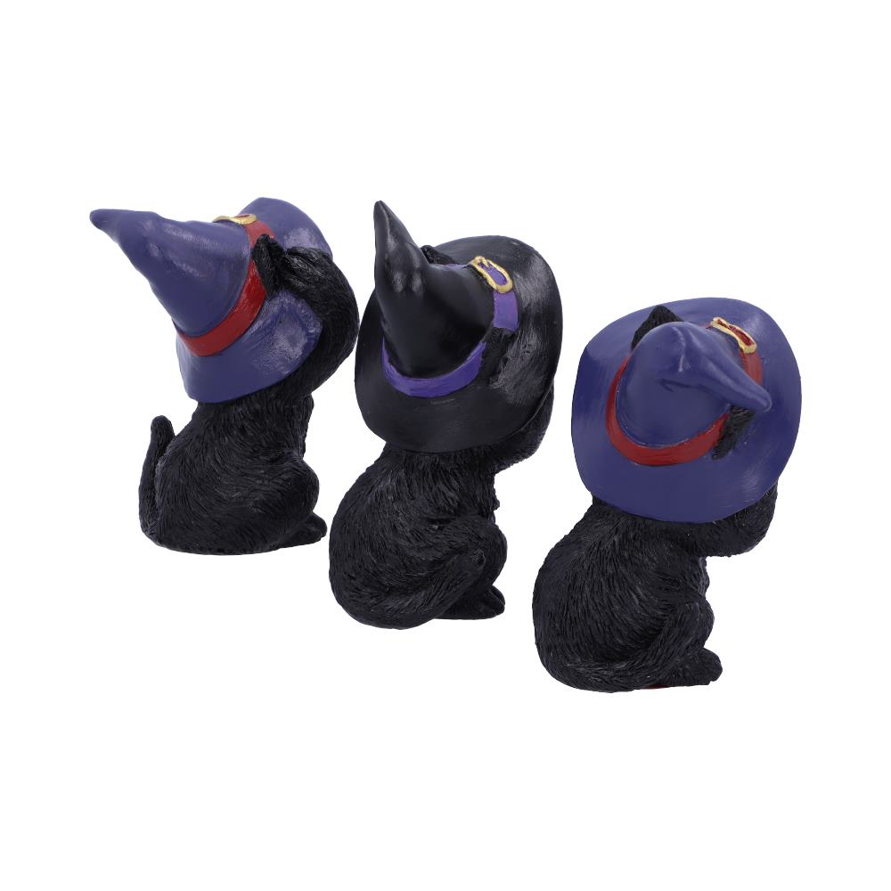 Three black cat figurines wearing pointed purple witch hats sit facing backward in a row, each hat adorned with a red or purple band and a gold buckle, on a plain white background.