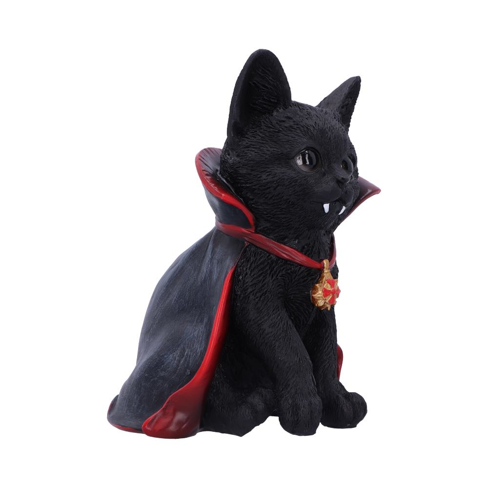 A black cat figurine wears a vampire cape with red lining and a gold medallion, sitting upright against a plain white background. It has small fangs protruding from its mouth.