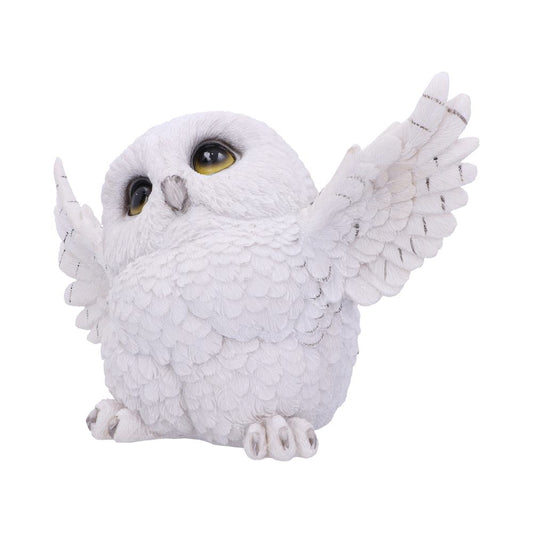 A white owl figurine with detailed feathers spreads its wings, sitting against a plain, light background. Its large, expressive eyes are prominently visible.