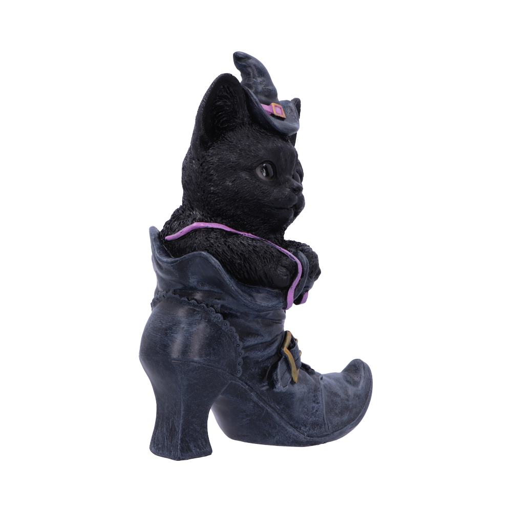 A black cat figurine wearing a witch hat sits inside a high-heeled boot, adorned with a purple ribbon, against a plain white background.