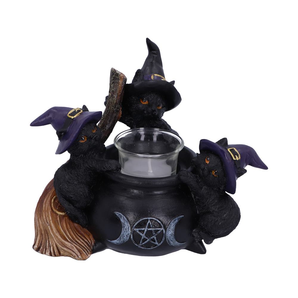 Three black kittens wearing pointed hats climb a black cauldron with a candleholder on top, next to a broom. The cauldron has a triple moon symbol and a pentagram on it.