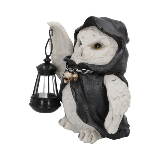 A white owl figure with a hooded black cloak holds a lantern in its wing. Skulls hang from a chain around its neck. The background is plain and white.