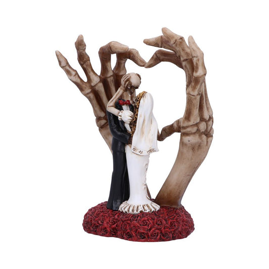 A skeleton couple in wedding attire embraces on a red rose base, encircled by sculpted skeletal hands forming a heart shape.
