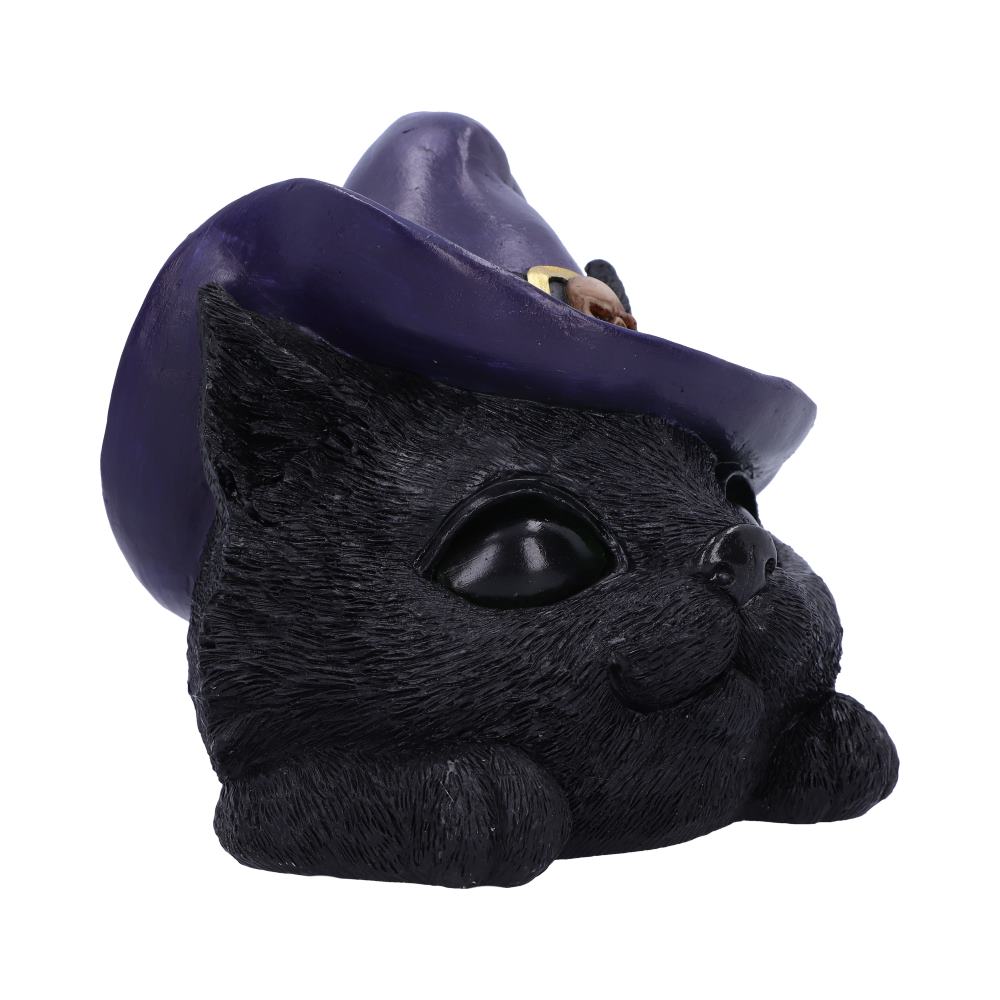 A black cat figurine lies with a purple witch hat tilted forward, exuding an enchanting, mystical vibe in a neutral setting.