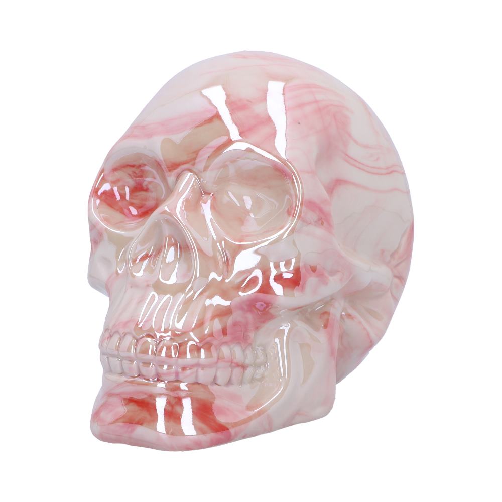 A glossy ceramic skull with pink and white marbling stands isolated against a plain white background, showcasing intricate detailing on its surface.