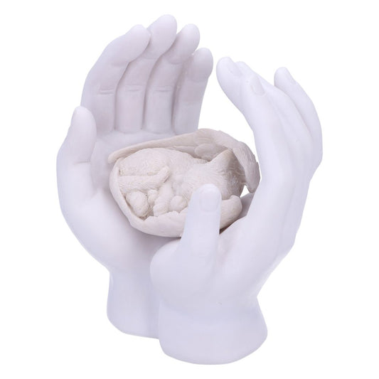 A pair of white sculpted hands gently cradle a small, curled-up animal figure, resembling a sleeping cat, against a plain white background.