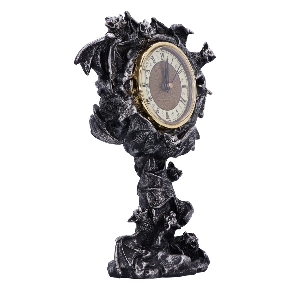 A decorative clock encased in a golden rim, supported by a sculpted base featuring numerous bats with outstretched wings, set against a plain white background.