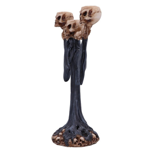 Three skull-topped draped figures rise as a tall blackened pedestal, the skulls appearing to gaze forward while a base of clustered tiny skulls anchors the piece on a white background.