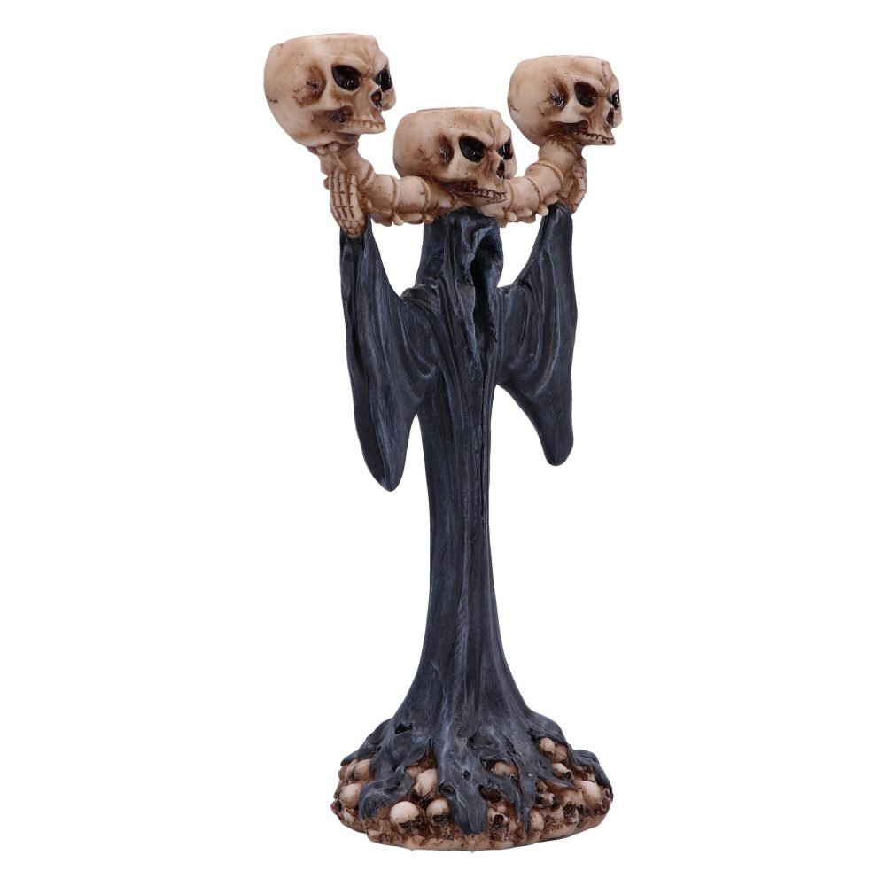 A candlestick holder, shaped like a grim reaper wearing black robes, holds three skull candle holders. The base of the candlestick is surrounded by smaller skulls.