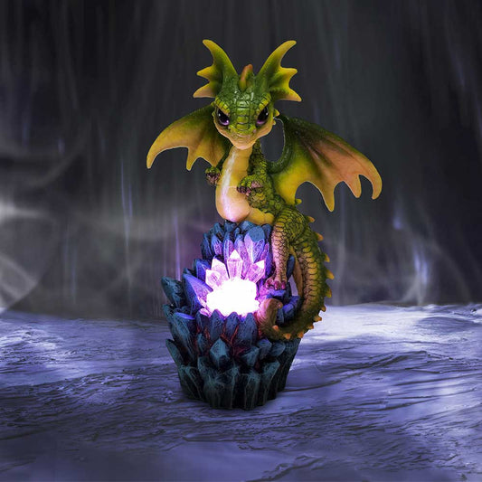 A small, green dragon perches on glowing purple crystals in a dark, misty environment, creating a mystical atmosphere.