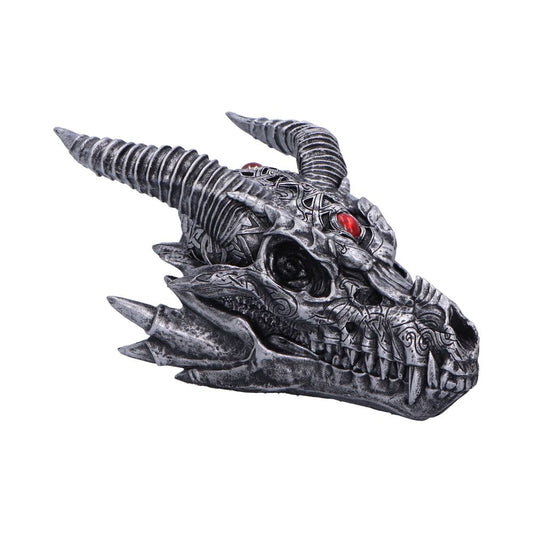 A detailed gray dragon skull with intricate carvings and red gemstone eyes sits against a plain white background. The skull features long, spiraled horns and sharp, prominent teeth.