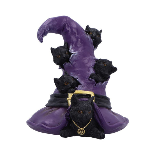 A whimsical sculpture of black cats peeking from a tall, twisted purple wizard hat adorned with a gold buckle. One cat wears a gold necklace with a pentacle charm.